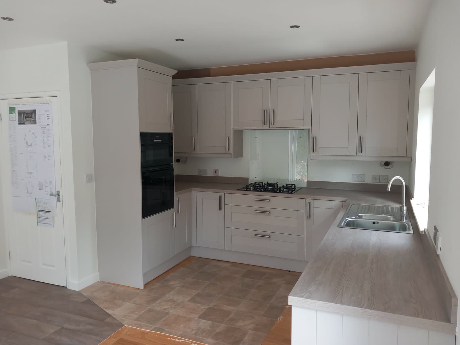 Grey shaker kitchen with glass splashback